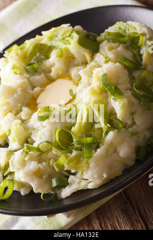 Irische Küche: Colcannon Kartoffelpüree mit Wirsing und Butter auf einem Teller-Makro. vertikale Stockfoto