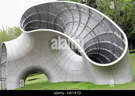 Moderner Skulptur aus Stahl und Aluminium gefertigt und montiert mit Muttern und Schrauben-obere Ebene des Platzes Rasen des Hinokicho Koen-Park auf der Rückseite Stockfoto