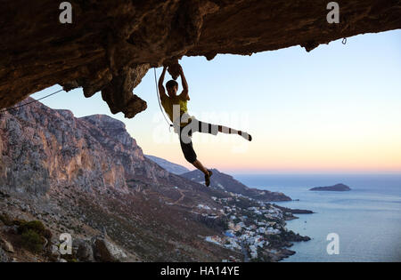 Kletterer auf Handgriffe beim Klettern überhängenden Felsen springen Stockfoto