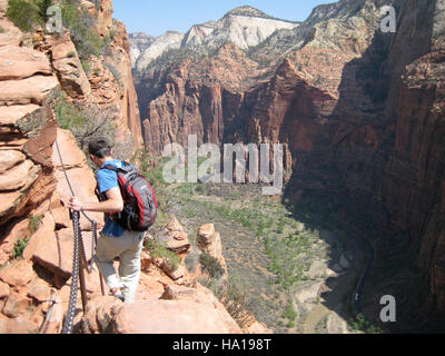 Dieses Bild zeigt einen Wanderer auf dem Angels Landing Trail im Zion National Park, bekannt für sein anspruchsvolles Gelände und seine atemberaubende Aussicht. Angels Landing ist ein beliebtes Wanderziel für abenteuerlustige Besucher, die einen Panoramablick auf den Park suchen. Stockfoto