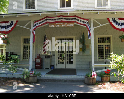 Der Eingang zur Lake Crescent Lodge im Olympic National Park zeigt eine patriotische Flagge, die den Nationalstolz symbolisiert. Dieses Gebiet ist Teil des vielfältigen Ökosystems des Parks und zieht Besucher zu seiner natürlichen Schönheit und Outdoor-Aktivitäten an. Stockfoto
