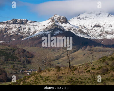 Der erste Schnee. Blick auf den Pas de Peyrol Straße (D17 Straße) und das Mandaille Tal. Cantal, Auvergne, Frankreich. Die schneebedeckten Gipfel des Puy Mary in den Wolken. Stockfoto