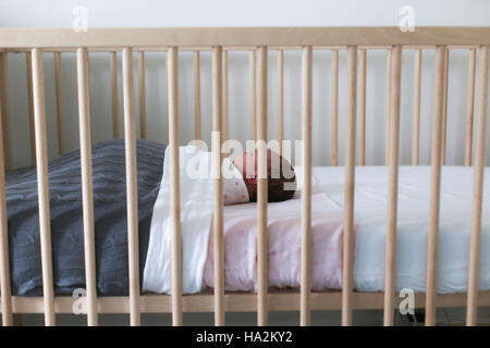 Babymädchen schlafen im Kinderbett Stockfoto