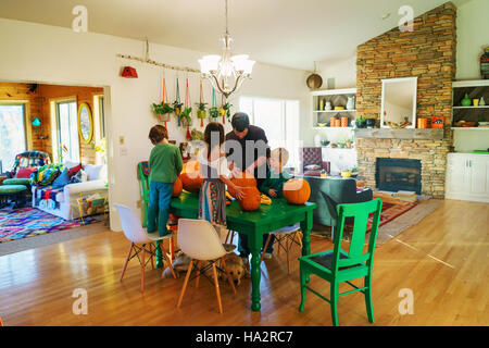 Vater und seinen drei Kindern vorbereiten Kürbisse in Küche Stockfoto