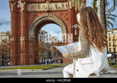 in Barcelona für einen perfekten Winter. Gesehen von hinten elegante Frau in Ohrenschützer in der Nähe von Arc de Triomf in Barcelona, Spanien auf der Karte Stockfoto