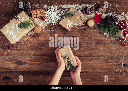 Des Mädchens Hände halten ein Weihnachtsgeschenk Stockfoto