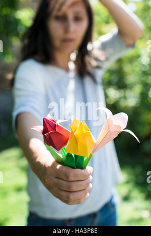 Frau halten Origami Blumenstrauß. Origamy Tulpen Stockfoto