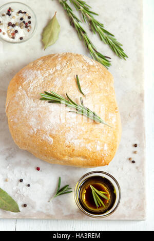 Frischem Ciabatta-Brot mit Rosmarin und Olivenöl extra vergine auf rustikale weißen Hintergrund Stockfoto