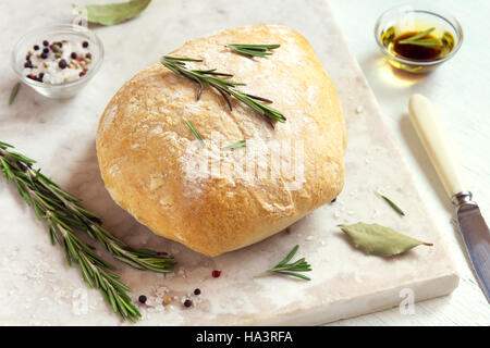 Frischem Ciabatta-Brot mit Rosmarin und Olivenöl extra vergine auf rustikale weißen Hintergrund Stockfoto
