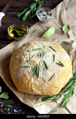 Frische hausgemachte Ciabatta Brot mit Rosmarin und Olivenöl extra vergine auf rustikalen hölzernen Hintergrund Stockfoto