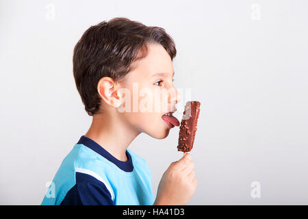 Young kid lecken Schokoladeneis bar Stockfoto