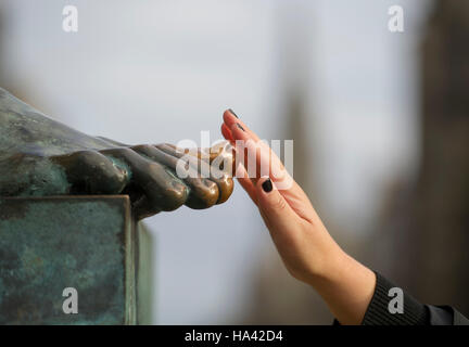 Touristischen berührt der Großzehe auf die Statue des Philosophen David Hume, der außerhalb der High Court auf Edinburghs Royal Mile sitzt. Stockfoto