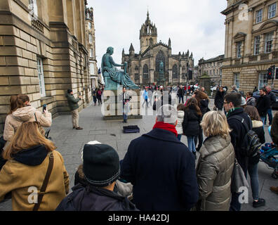 Touristen schauen Sie sich die Statue des Philosophen David Hume (1711-1776) auf Edinburghs Royal Mile. Stockfoto