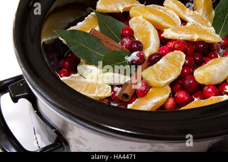 Hausgemachte Preiselbeersauce Zutaten Zimt, Orangen, Preiselbeeren, Lorbeerblatt in einem Topftopf isoliert auf einem weißen Hintergrund simmering Stockfoto