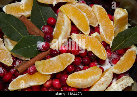 Nahaufnahme der hausgemachten Preiselbeersauce Bestandteile von Zimt, Orangen, Preiselbeeren, Lorbeerblatt in einem Topftopf simmering Stockfoto