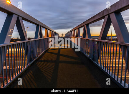 Schöner Sonnenuntergang Perspektive, Langzeitbelichtung Schuss eine Fußgängerbrücke über die stark frequentierten Autobahn M62 in Leeds Stockfoto