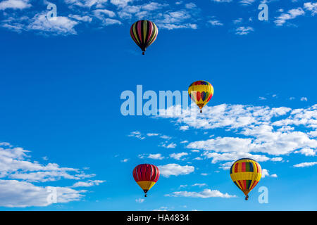 Heißluftballons fliegen über die Stadt Albuquerque, New Mexico während der Massenaufstieg an der jährlichen internationalen Hot Air Balloon Fiesta im Oktober Stockfoto