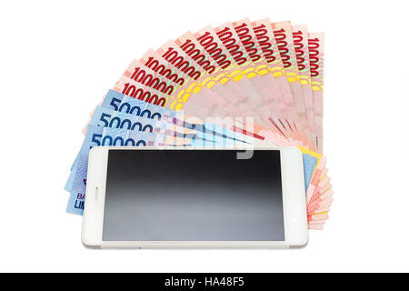 Smartphone über den Haufen von indonesische Rupiah (IDR) Banknoten auf dem weißen Hintergrund. Stockfoto