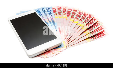 Smartphone über den Haufen von indonesische Rupiah (IDR) Banknoten auf dem weißen Hintergrund. Stockfoto