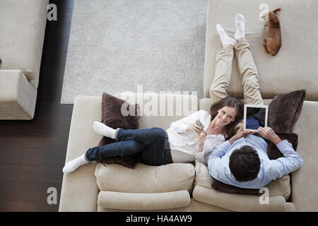 Paar mit digital-Tablette zu Hause auf Sofa sitzen, Ansicht von oben Stockfoto