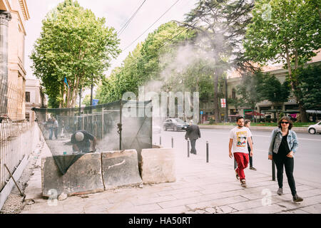 Tiflis, Georgien - 20. Mai 2016: Die Passanten Menschen zu Fuß entlang der Reparaturstelle des Fahrbahnbelags auf Rustaveli Avenue im Frühling. Stockfoto