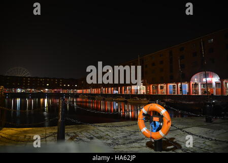 Albert Dock, Liverpool, Merseyside, England, in der Nacht mit einem Riesenrad im Hintergrund Stockfoto