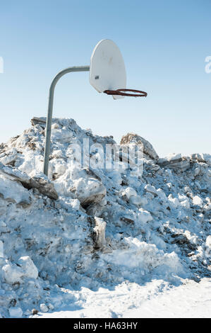 Ein Basketballkorb im Winter, umgeben von einem Haufen von schaufelten Schnee in Port Stanley, Ontario, Kanada. Stockfoto