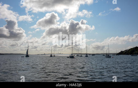 Segelboote vor Anker unter blauem Himmel mit weißen Wolken in Dale Bucht mit Pembrokeshire Ölraffinerie im Hintergrund. Stockfoto