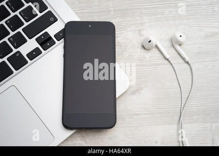 Smartphone mit Kopfhörer auf den Tisch Stockfoto