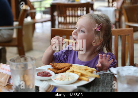 Mädchen essen Pommes Frites. Stockfoto