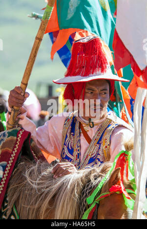 Ein Khampa Reiter, gekleidet in zeremoniellen Kleid auf dem Yushu Horse Racing Festival in Qinghai Provinz, China. Stockfoto