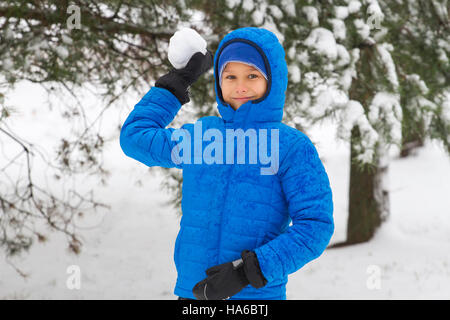 Junge werfen Schneeball. Winterspaß Stockfoto