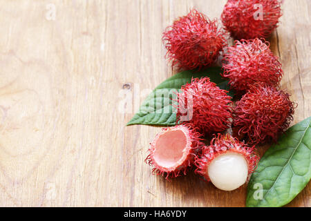 Natürliche Bio Litschi-Frucht (Rambutan) auf einem Holztisch Stockfoto