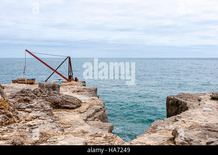 Der rote Kran ist Teil der jetzt stillgelegten Portland Bill Stein Verladungskai auf der Klippe am südlichsten Punkt von Portland Stockfoto