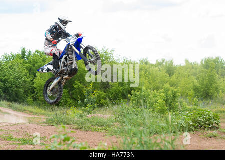 Die jungen Sportler auf einem Motorrad Sprung Stockfoto