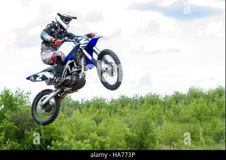 Die jungen Sportler auf einem Motorrad Sprung Stockfoto