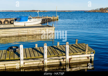 Tjurko, Schweden - 24. November 2016: Reisedokumentation von kleinen lokalen Yachthafen im Herbst. Ein Motorboot vertäut am Hafen und in den Schären sichtbar in der Stockfoto