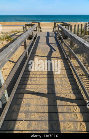 Brett zu Fuß zum Strand mit Schatten, Sand und Meer im Hintergrund Stockfoto