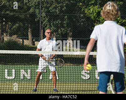 Großvater und Enkel zusammen Tennis zu spielen. Stockfoto