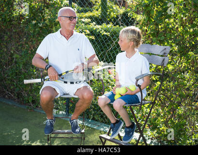 Großvater und Enkel zusammen Tennis zu spielen. Stockfoto