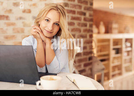 Attraktive junge Frau mit einem Laptop zu Hause Stockfoto