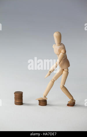 Holz Figur verstärkt auf Stapel von Münzen Stockfoto