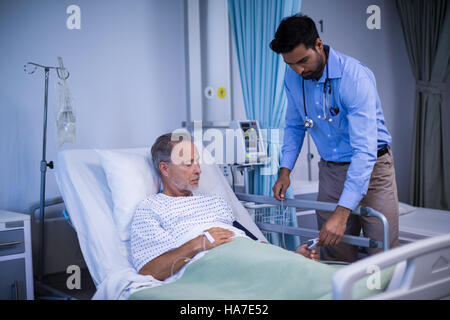 Herr Doktor putting Herzfrequenz-Sensor am Finger des Patienten Stockfoto