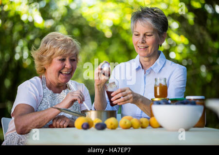 Frauen in Führungspositionen Marmelade in eine Flasche füllen Stockfoto