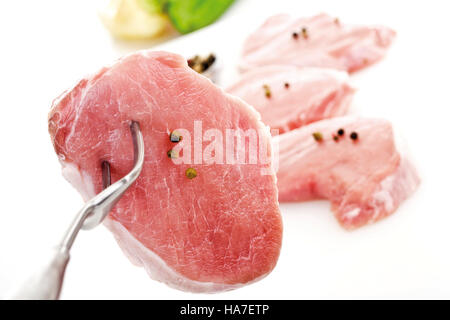 Lende Schweineschnitzel, roh auf eine Fleischgabel Stockfoto