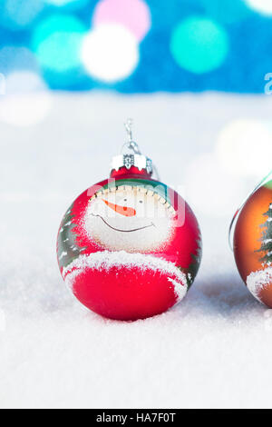 Gruppe von bunten Weihnachtskugeln auf einem weißen Schnee Hintergrund. Stockfoto