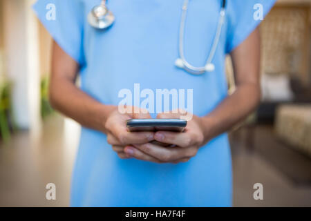 Arzt mit Mobiltelefon im Krankenhaus Stockfoto