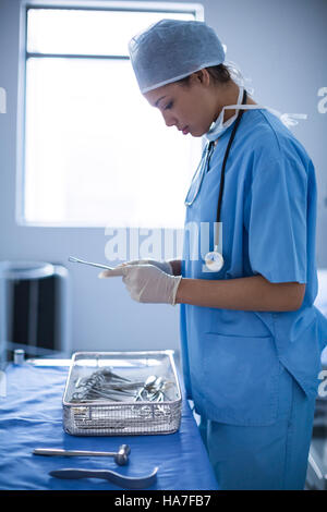 Weibliche Chirurg Holding chirurgische Geräte Stockfoto