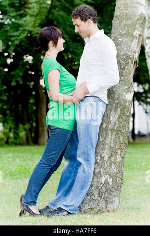 Paar in Liebe an einen Baum gelehnt Stockfoto