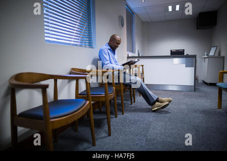 Patienten lesen Magazin im Korridor Stockfoto